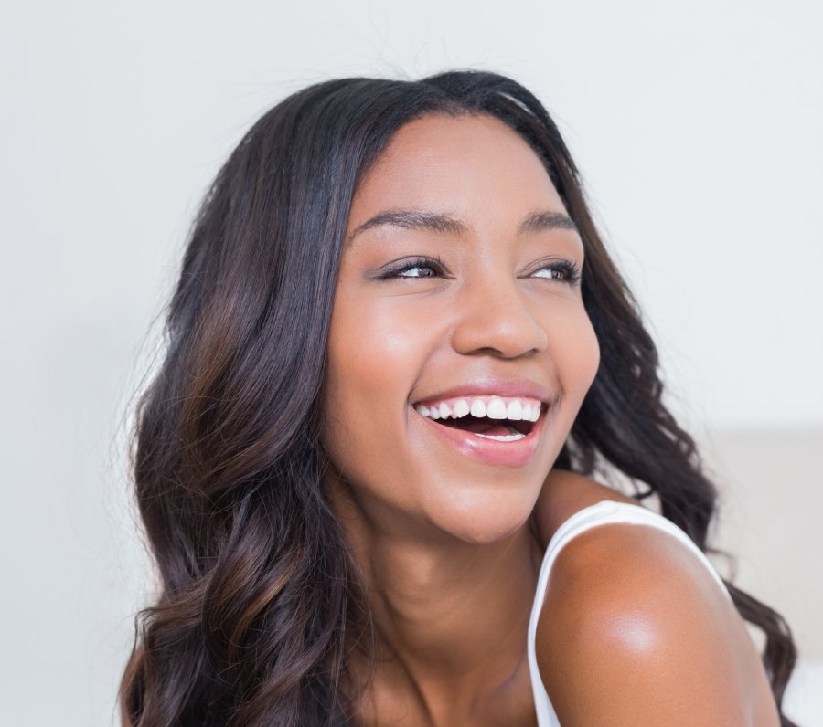 Beautiful black woman with big smile showing straight, white teeth.